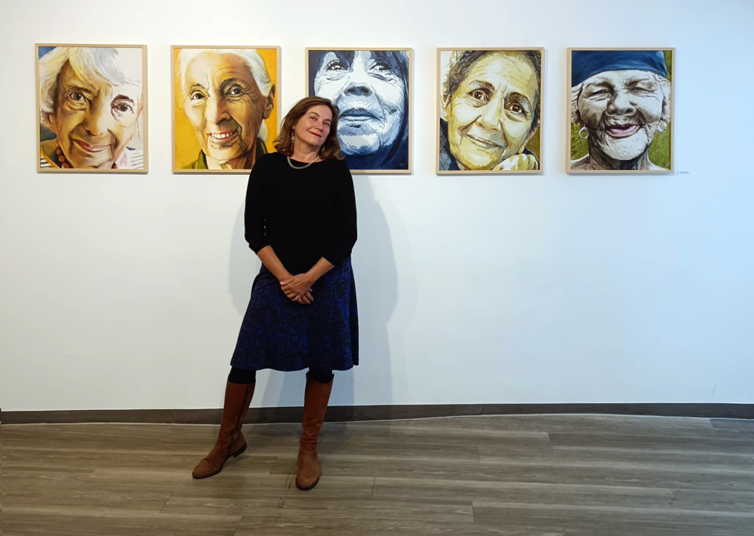 Foto von Gabriele Riedel vor ihren ausgestellten Acrylbildern in der Ausstellung "Dreistimmig" in der Galerie Zwischenraum in Weilheim/Obb., Okt. 2025